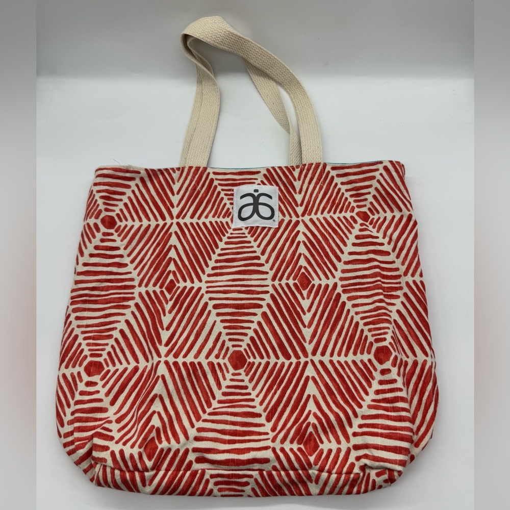 Arbonne Brand Tote Bag featuring geometric red and white pattern.